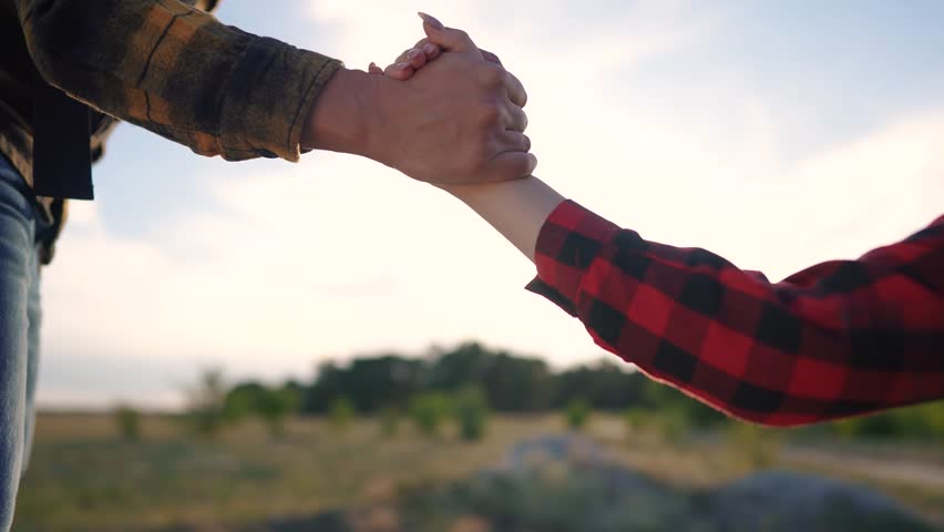 Group tourists helps lend a helping hand. Teamwork business travel concept. The man extends his hand and girl helps her climb rocks. Group tourists help lifestyle each other suive on their journey.