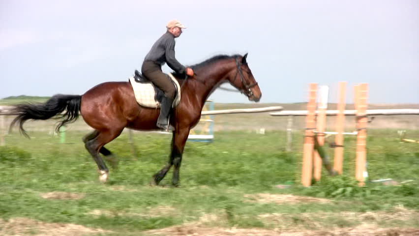 Horseman jumps through the barrier (on horseback. Slow motion