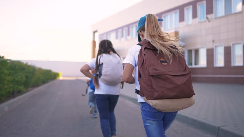 A group of girls running back to school. Bag elementary happy concept. Children running around in a backpack at school. A group of children running back to school backpacks with their. lifestyle.