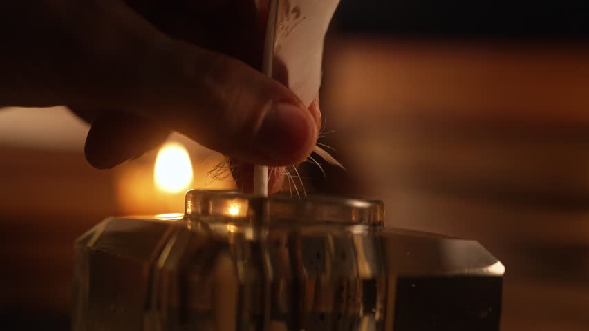 Man writing letter with feather quill pen under warm glow light of old candle burning. Gentleman hand dips in inkwell. Vintage cozy scene from 18th or 19th century. Correspondence concept.