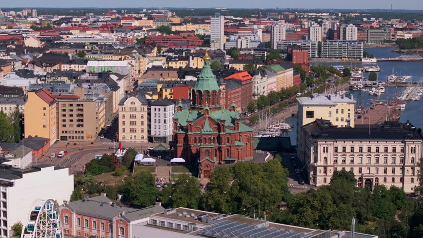 Aerial view of Helsinki, Finland focusing on Uspenski Cathedral. Cars are driving through the city streets on a sunny day