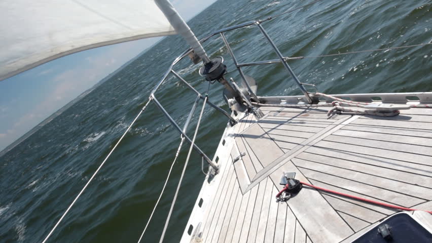 View on a wooden deck in the rostrum of yacht. Yacht runs over the waves in
