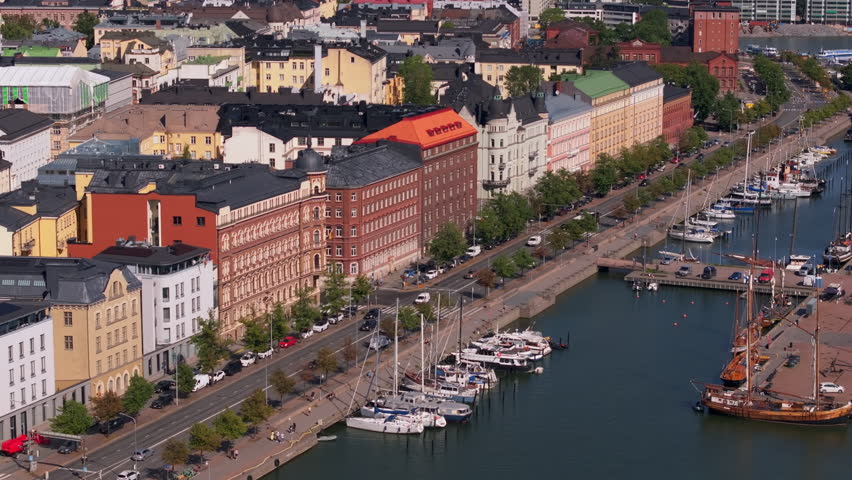 Aerial view of Helsinki harbour with boats gently swaying on the water. Tourists and locals are enjoying a sunny day in the Capital of Finland