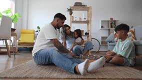 Latin American family enjoying quality time playing table football on the floor of their cozy living room - Powered by Shutterstock - Get 15% off with code: PIKWIZARD15