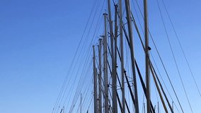 Masts of small yachts against the blue sky. Many yacht masts gently sway against the bright sky. Sports and recreation - Powered by Shutterstock - Get 15% off with code: PIKWIZARD15