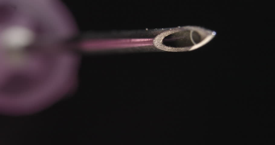 Extreme Close-up of Droplets of Liquid Falling From Tip of Hypodermic Needle