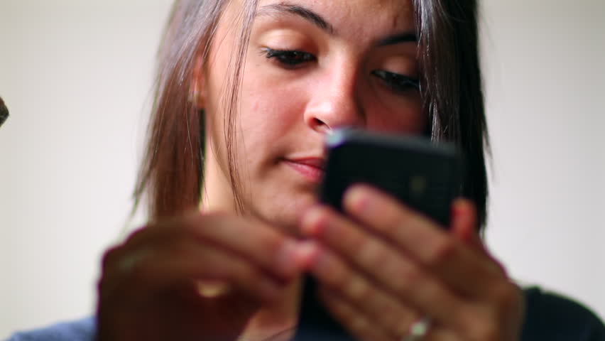 Woman using a smartphone with focused expression, illustrating a moment of digital engagement, representing communication, technology, and modern lifestyle