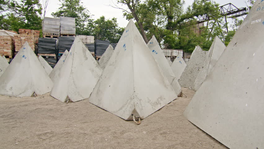 Concrete pyramids arranged outdoors at a construction site. Precast concrete structures for infrastructure or engineering projects