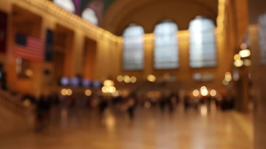 people walking and moving around inside grand central terminal in manhattan (out of focus footage) burry lights and shapes windows traffic commute transit transport