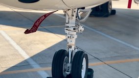 Private Jet Landing Gear with Remove Before Flight Tag - Pre-Flight Safety on Tarmac. Nose wheel of private jet. High quality detail footage. - Powered by Shutterstock - Get 15% off with code: PIKWIZARD15