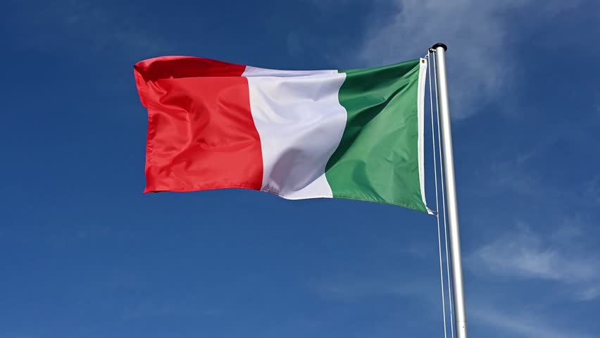 Slow motion, flag of Italy fluttering in the wind against a blue sky