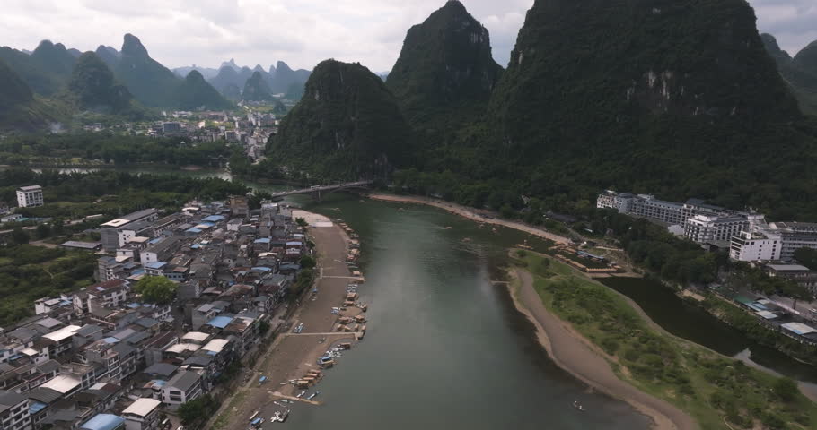Drone rising along the Li river in the Yangshuo town, in cloudy Guangxi, China