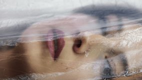Vertical video. Artistic portrait of woman under transparent film shroud creating dreamy mysterious atmosphere. - Powered by Shutterstock - Get 15% off with code: PIKWIZARD15