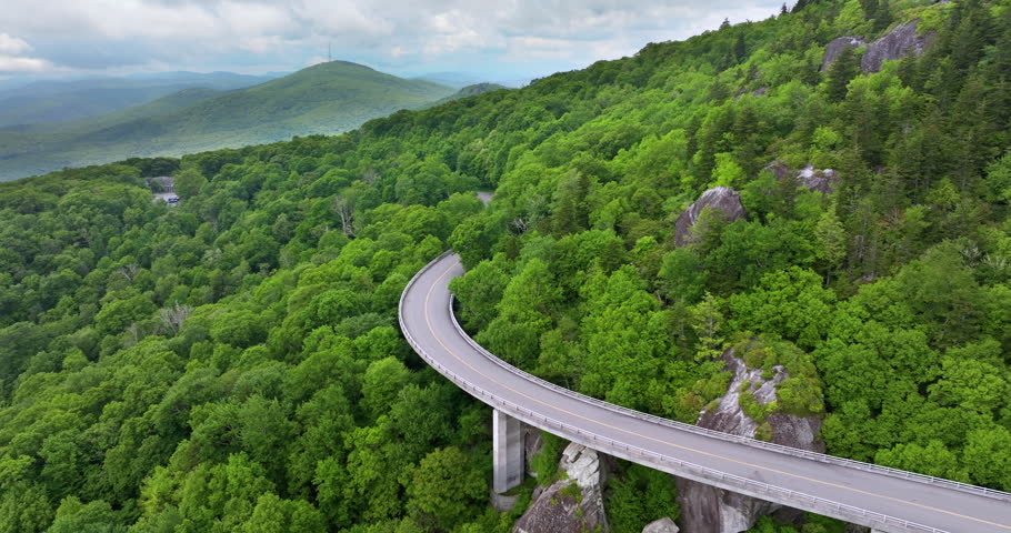 Linn Cove Viaduct on Blue Ridge Parkway road in summer woods of Appalachian mountains with green canopies in colorful forest. Road trip driving in wild nature in summertime season