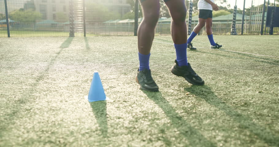 Feet, person and jump with cone for soccer of fitness practice, warm up guide and exercise performance. Athlete, beacon and routine with football challenge, sports progress and game training on field
