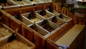 Various nuts and seeds in paper bins at a bulk food store. Wooden containers with product labels displayed in a row. Indoor grocery shopping scene - Powered by Shutterstock - Get 15% off with code: PIKWIZARD15