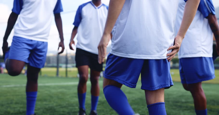 Football player, team and legs with stretching for fitness on field with warm up, exercise and workout for competition. Sport, group and training on grass pitch for soccer match, performance and game
