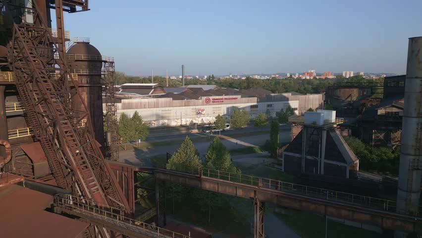 Ostrava , Czech Republic - 09 12 2024: Large industrial structure with multiple levels, pipes, and metal frameworks against a clear sky