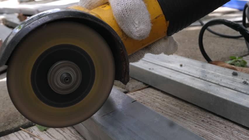 Electric grinder cutting the iron pipe. Close up shot. DIY and steel working concept