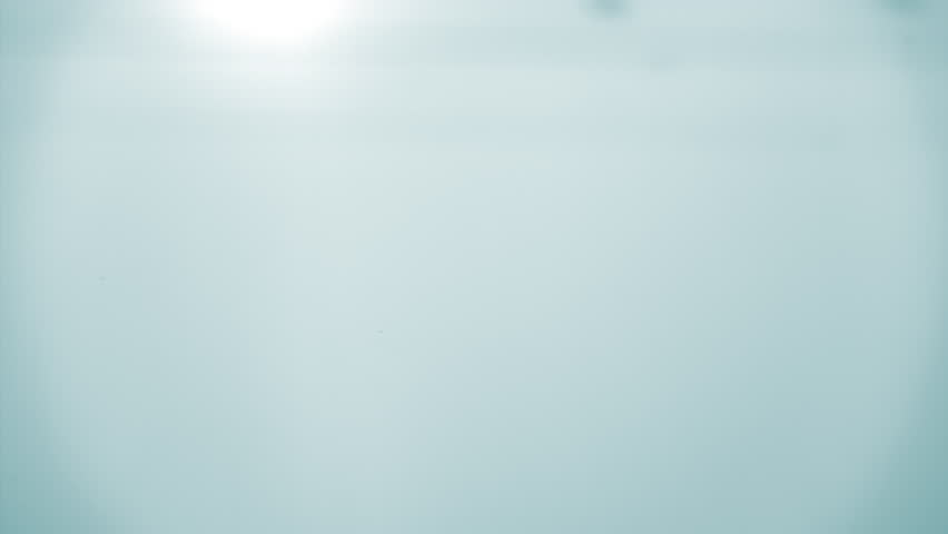 Natural mineral water splashing. Crystal clear drop of cosmetic essence serum falling in slow motion. Body moisturizing cosmetics formulating. Commercial beauty product blue liquid abstract background
