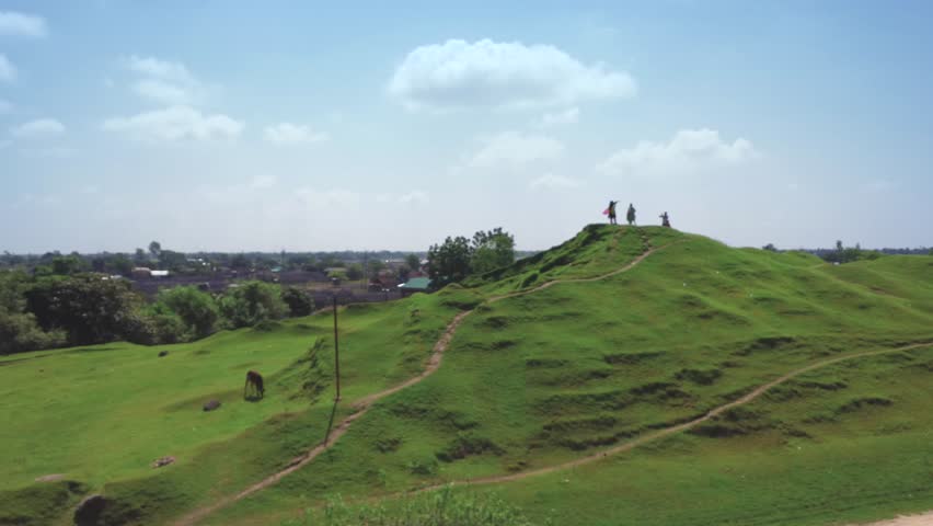 Tranquil Rural Scene: People, Cows, and Vehicles on a Mud Road