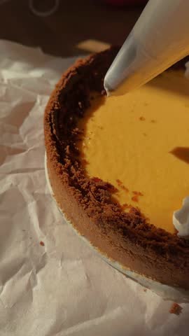 Pumpkin pie sprinkled with drizzled with cream. Delicious and healthy dessert for tea or coffee on warm autumn evenings. Eating of tasty pumpkin pie at table. Vertical video