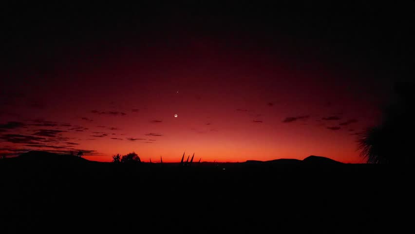 A landscape timelapse scene of cloudy sky moving over lake with trees at sunset.  green mountains covered with moving the sun brightness, morning sunrise from dawn to day light.