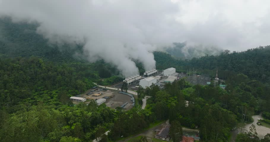 Aerial view of Geothermal station with steam and pipes. Geothermal power plant with smoking pipes and steam. Mindanao, Philippines.