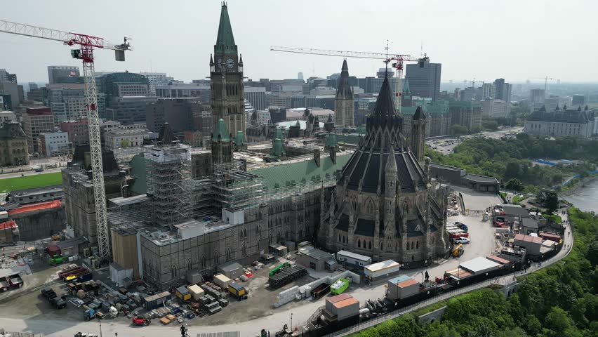 A historic moment captured in time: the iconic Canadian Parliament building undergoes renovations, showcasing scaffolding and construction workers amidst the iconic architecture.