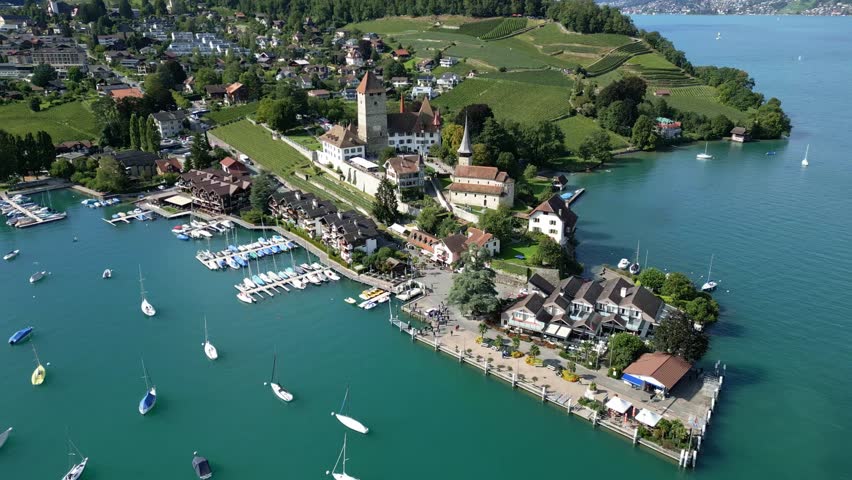 Aerial view with a drone of the castle in Spiez and the port with Thun lake in Canton of Bern in Switzerland.