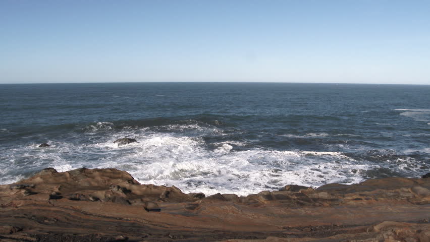 Slow motion of rough king tide waves crashing high above rocky coastline.