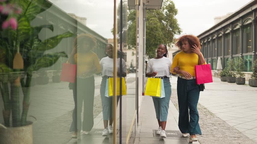 Gen z female friends shopping in city street. Diverse ethnicities.