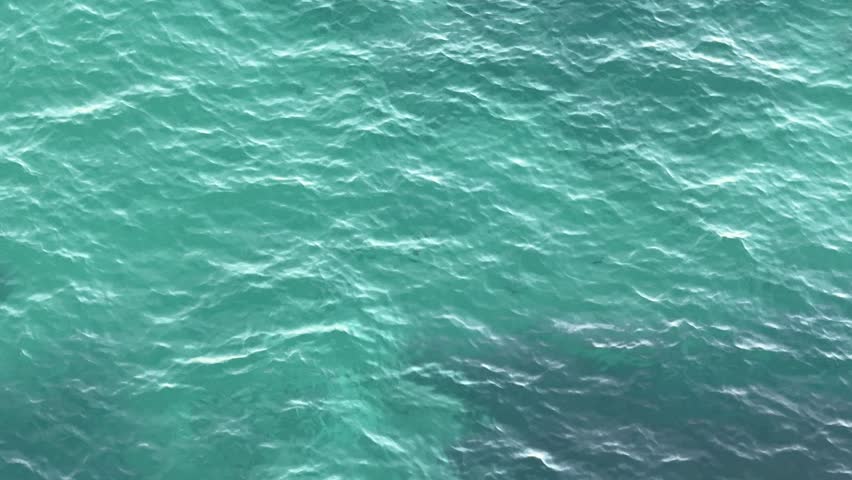 Sea blue glittering water ripples surface aerial view.