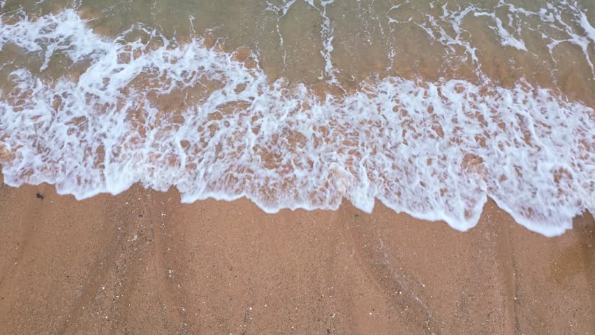 Close-up view from the wavering and bubbly waves on a beautiful plage, Bretagne, France.
