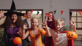 Portrait of Multiracial children celebrating Halloween party in house. Group of young kids dressed in Halloween costume holding trick-or-treat pumpkin basket and look at camera during festival at home - Powered by Shutterstock - Get 15% off with code: PIKWIZARD15