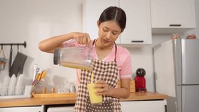 Asian woman making fresh fruit smoothies in blender in kitchen at home. Attractive female housewife feel happy and relax, enjoy preparing ingredients and making healthy drink for breakfast in morning. - Powered by Shutterstock - Get 15% off with code: PIKWIZARD15