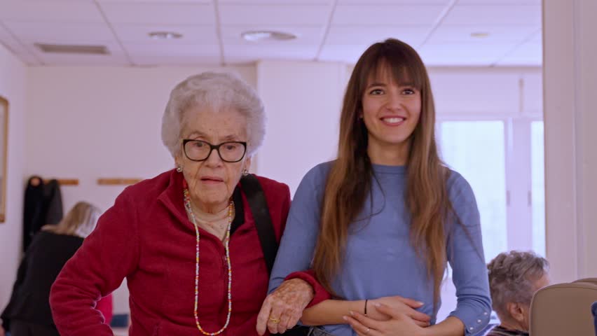Nurse providing care and support to an elderly woman in a bright nursing home, showcasing compassion and connection