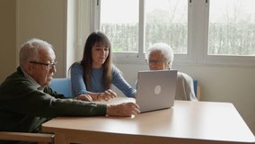 Nurse patiently teaches an elderly couple how to use a laptop, fostering digital literacy and connection - Powered by Shutterstock - Get 15% off with code: PIKWIZARD15