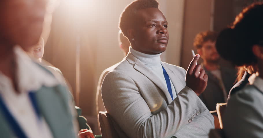 Business people, listening and night with crowd in seminar for workshop, staff training or presentation at conference. Young, group or employees in meeting, tradeshow or convention talk at workplace