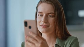 Woman shopping online at smartphone choosing purchases on screen closeup. Smiling brunette reading message at mobile phone in relaxed home atmosphere. Pretty lady enjoy internet communication indoors. - Powered by Shutterstock - Get 15% off with code: PIKWIZARD15
