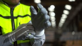 Close up hand worker wearing putting protective safety glove. Safety equipment for industry factory. Safety at work concept.
 - Powered by Shutterstock - Get 15% off with code: PIKWIZARD15