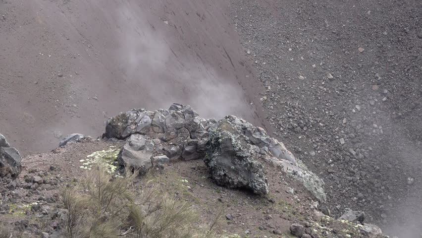 Close-up view of rock formations with smoke billowing from Mount Vesuvius volcano in Italy
