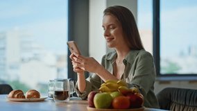 Morning girl enjoying smartphone messaging sitting at breakfast table closeup. Relaxed woman drinking fresh coffee looking mobile phone screen. Content smiling lady starting day with calm energy. - Powered by Shutterstock - Get 15% off with code: PIKWIZARD15