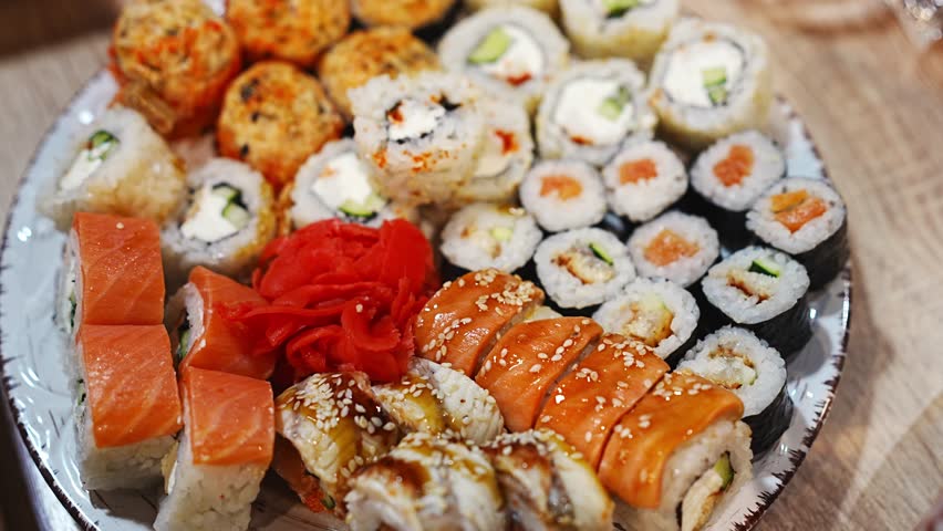 A large plate with an assortment of rolls. ordering and delivery of ready-made Asian dishes.