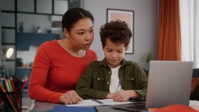 Happy African American family mother woman mom help with homework little lovely son boy child kid pupil schoolboy together studying e-learning laptop computer task online writing school home education - Powered by Shutterstock - Get 15% off with code: PIKWIZARD15