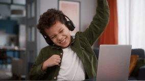African American son kid child boy in headphone at home typing browsing laptop playing video game computer distant play gaming online internet addiction win celebrate success achieve victory winning - Powered by Shutterstock - Get 15% off with code: PIKWIZARD15