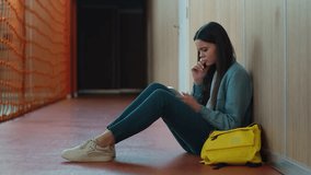 Sad upset failure stress pensive thinking girl female woman student pupil education studying sitting floor in school university college corridor using mobile phone smartphone online app social media - Powered by Shutterstock - Get 15% off with code: PIKWIZARD15