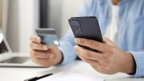 Close up of african american male hands using phone to make online transaction with credit card in business office. Shopper makes payment, pays bills, spends money on internet, Digital payment - Powered by Shutterstock - Get 15% off with code: PIKWIZARD15
