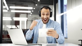 Excited african american businessman in wireless headphones watching sports match or competition using digital tablet sitting at workplace in business office. Happy man cheering for favorite team - Powered by Shutterstock - Get 15% off with code: PIKWIZARD15