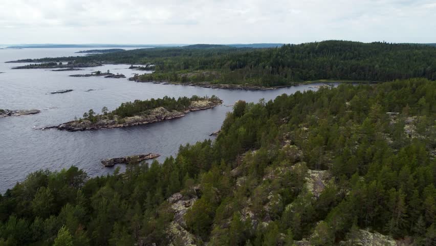 Russia, Lake Ladoga, Koyonsaari. View of the coast of the island in a cold lake. Beautiful nature of the Republic of Karelia. Panoramic view from the height of the Ladoga skerry islands. 4K